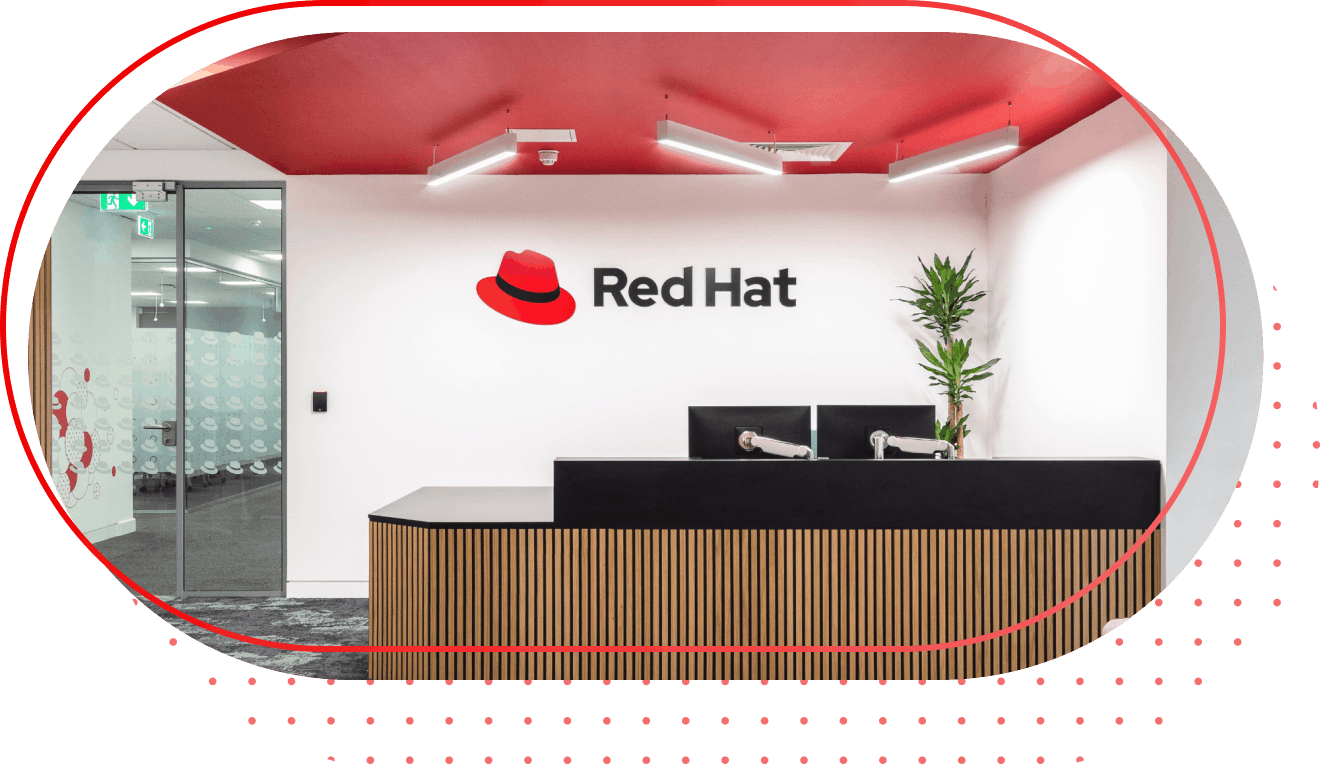 A Red Hat office with a red ceiling and the Red Hat logo on the wall