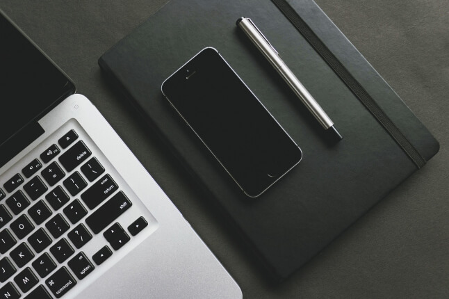 laptop computer and iphone with pen and notebook