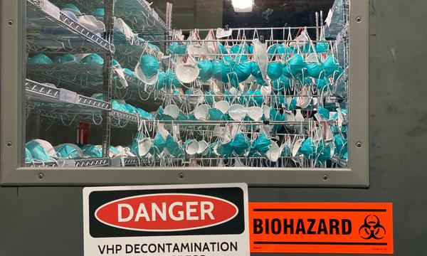 A view through a door window of N95 masks being decontaminated.